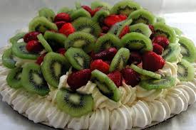 Pavlova filled with cream and fresh kiwi and raspberries